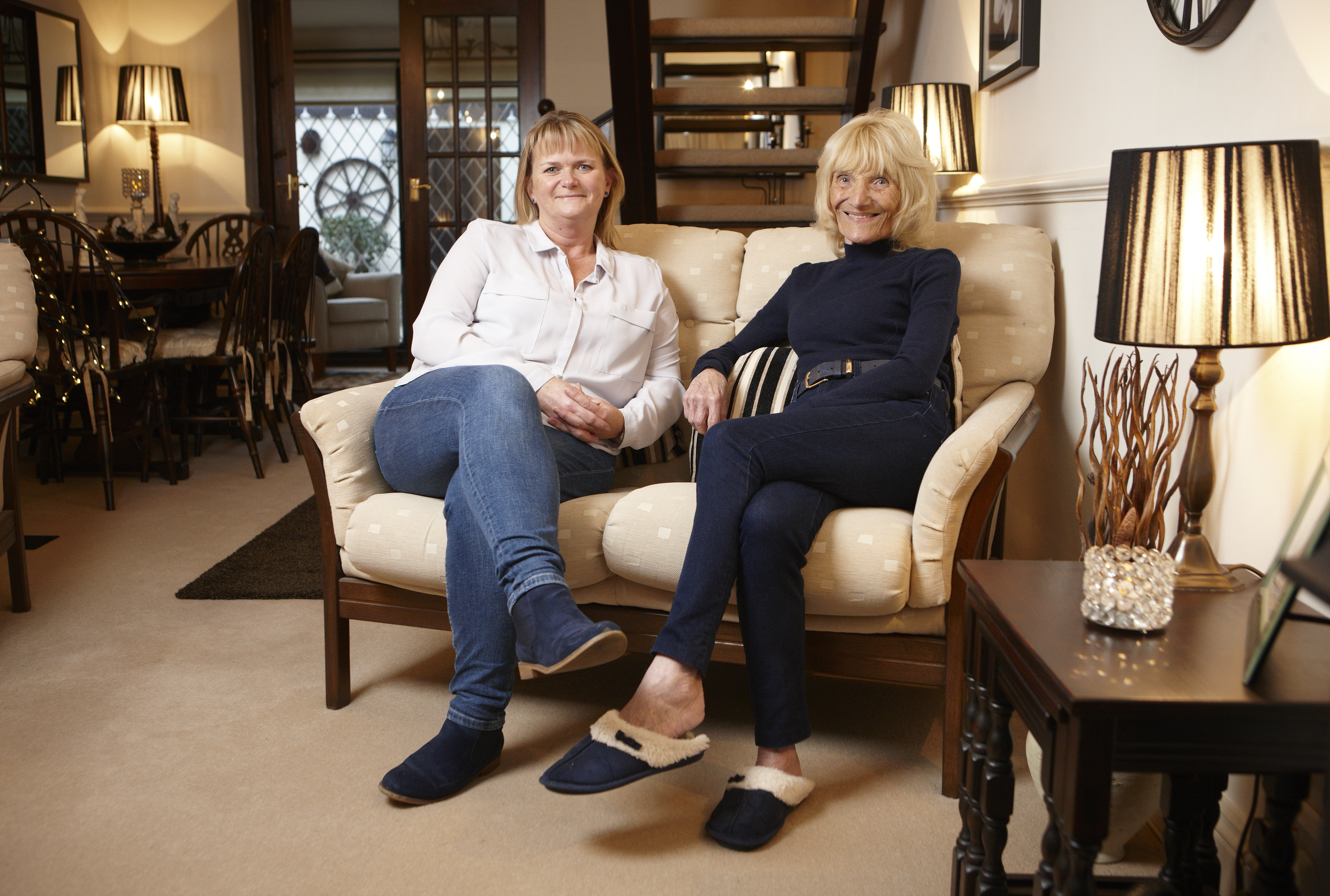 Pat, whose husband died of mesothelioma contracted at work, with her daughter in her living room