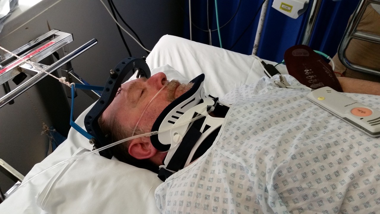 Injured man lying down in hospital bed