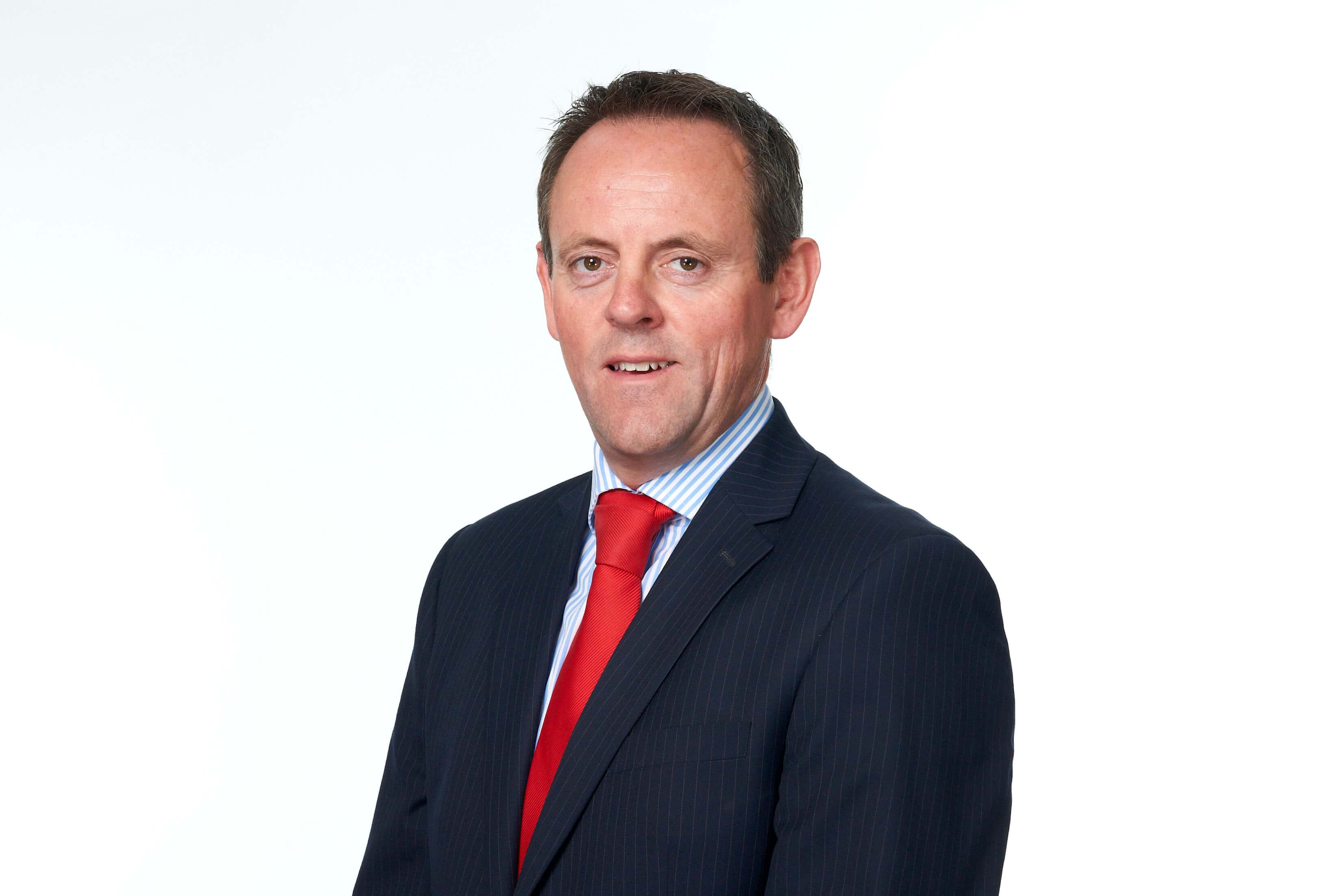 Simon Wilson, Serious Injury Solicitor, in a black suit with a red tie