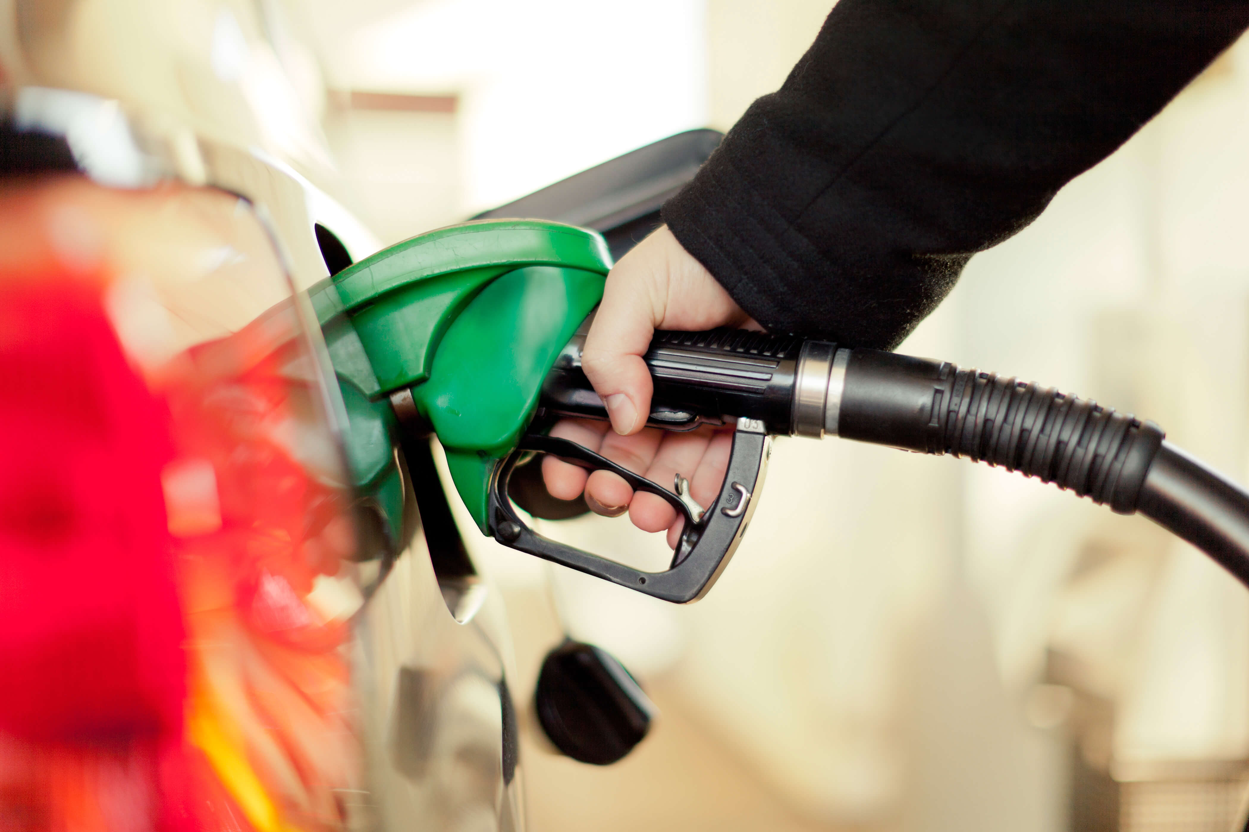 A driver fills up their car with petrol at a petrol station