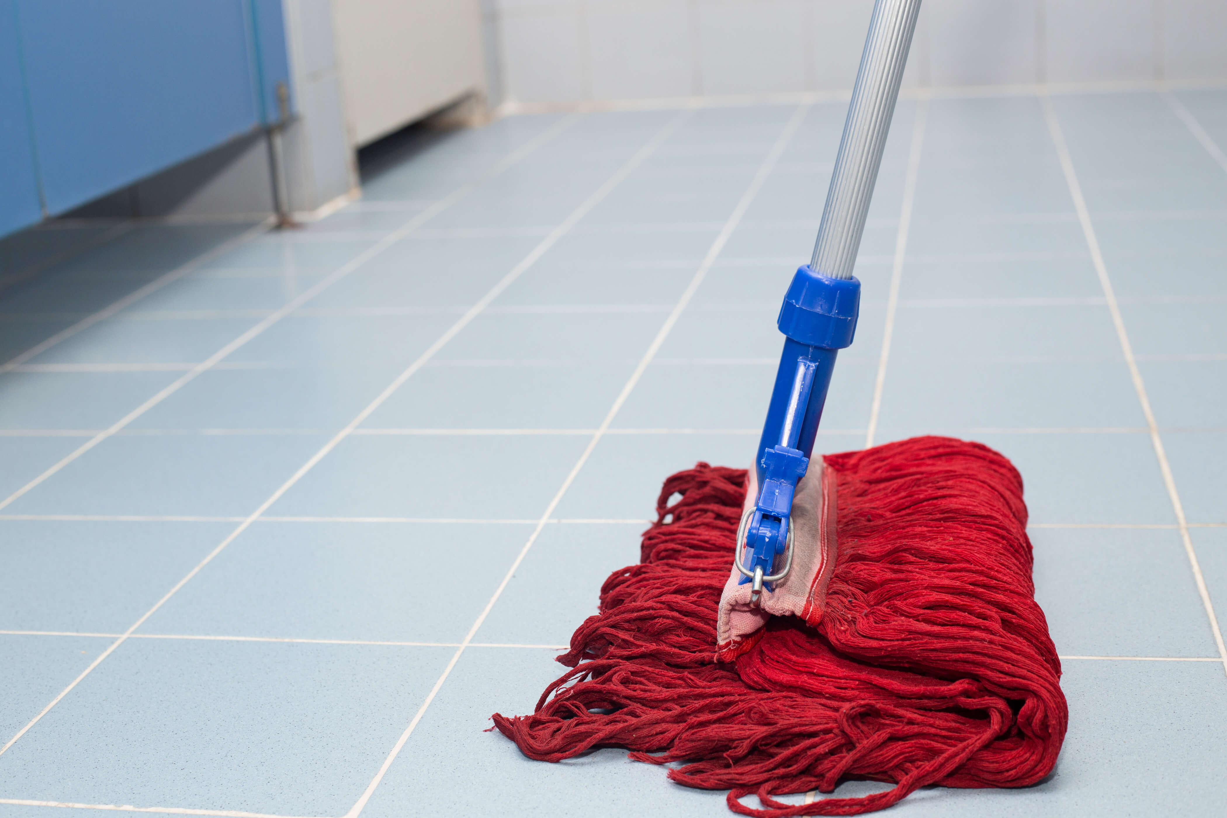 A mop wipes the floor of a rest room, which caused an accident at work