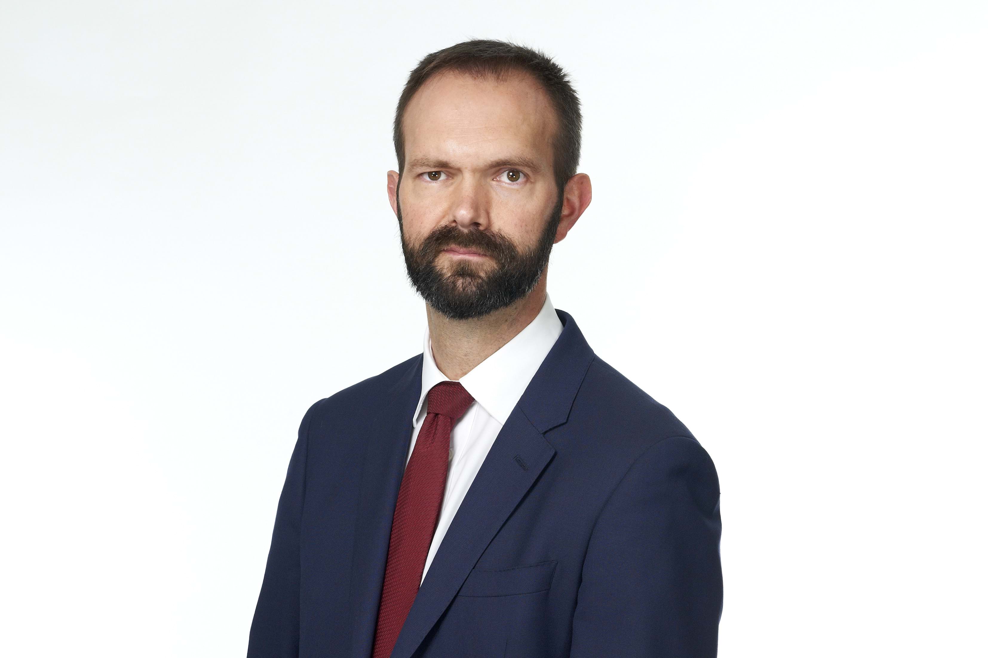 Paul Shevlin, an employment law solicitor at Thompsons Solicitors, wearing a blue suit and red tie