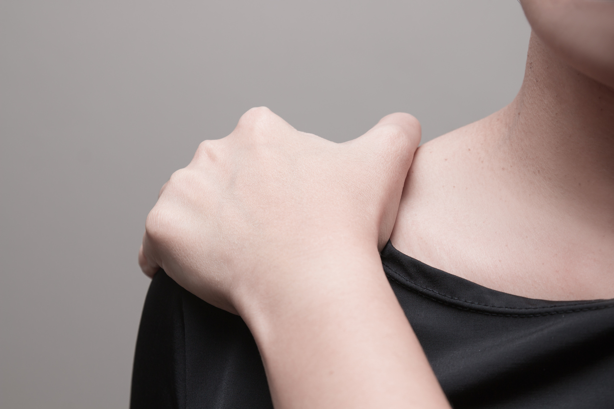 A woman touches her shoulder after she suffers a fall at work