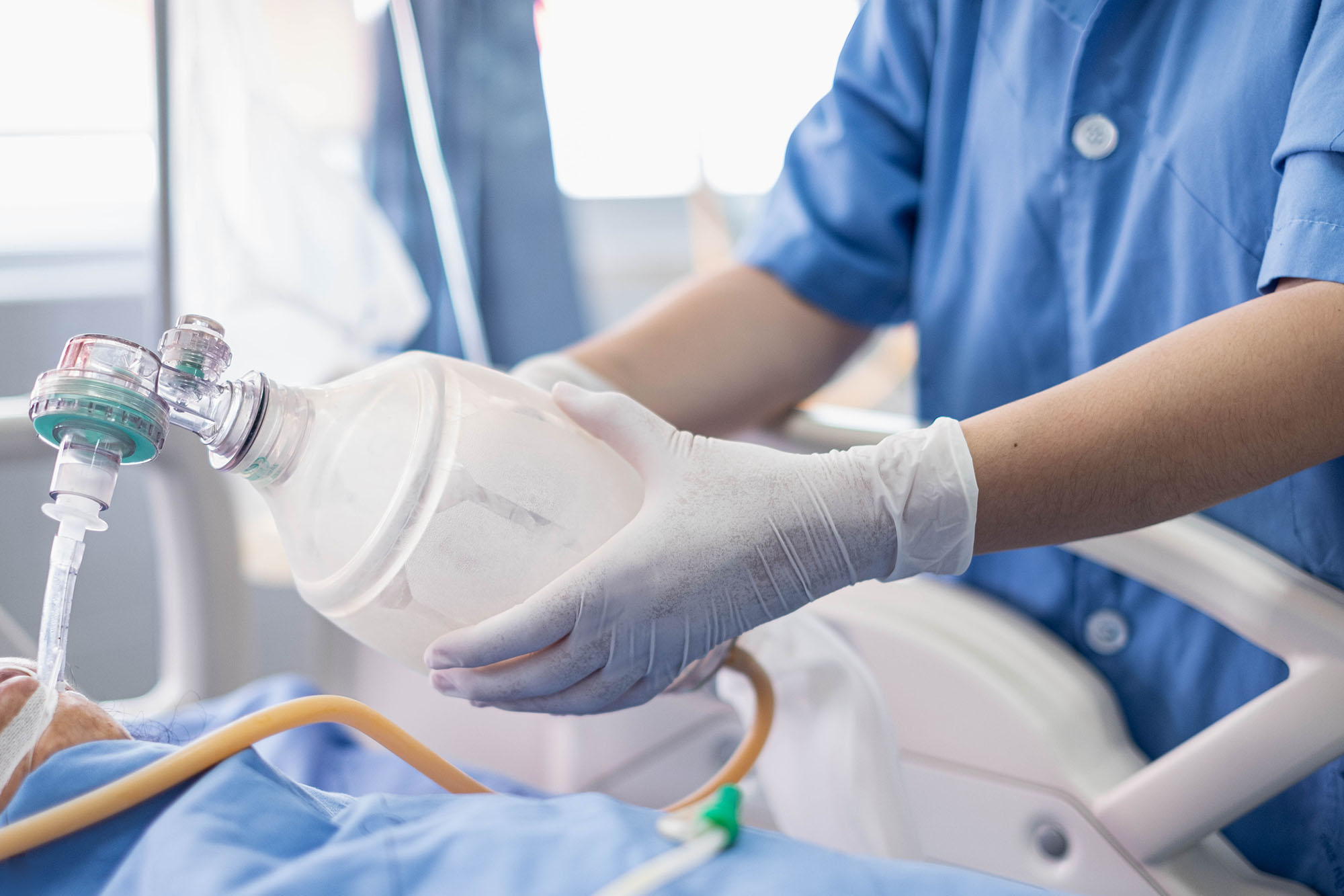 A nurse supports a patient to breath