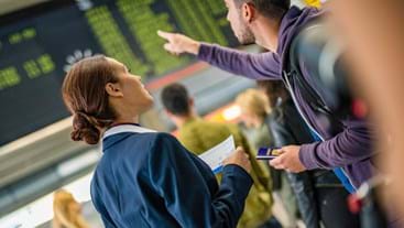 An airport employee gives help to a backpacker