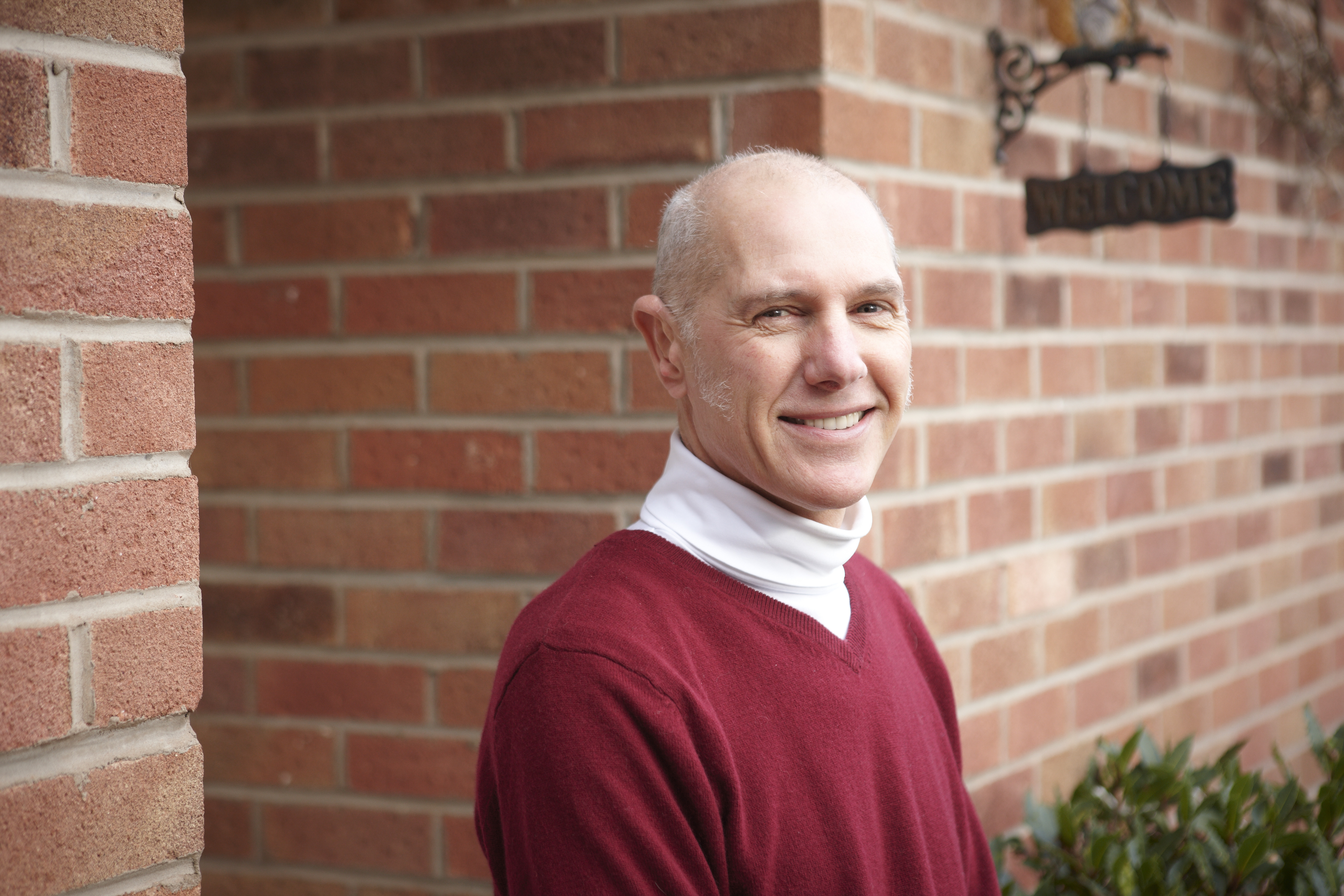 Robert Warren pictured in a red jumper outside his house, smiling