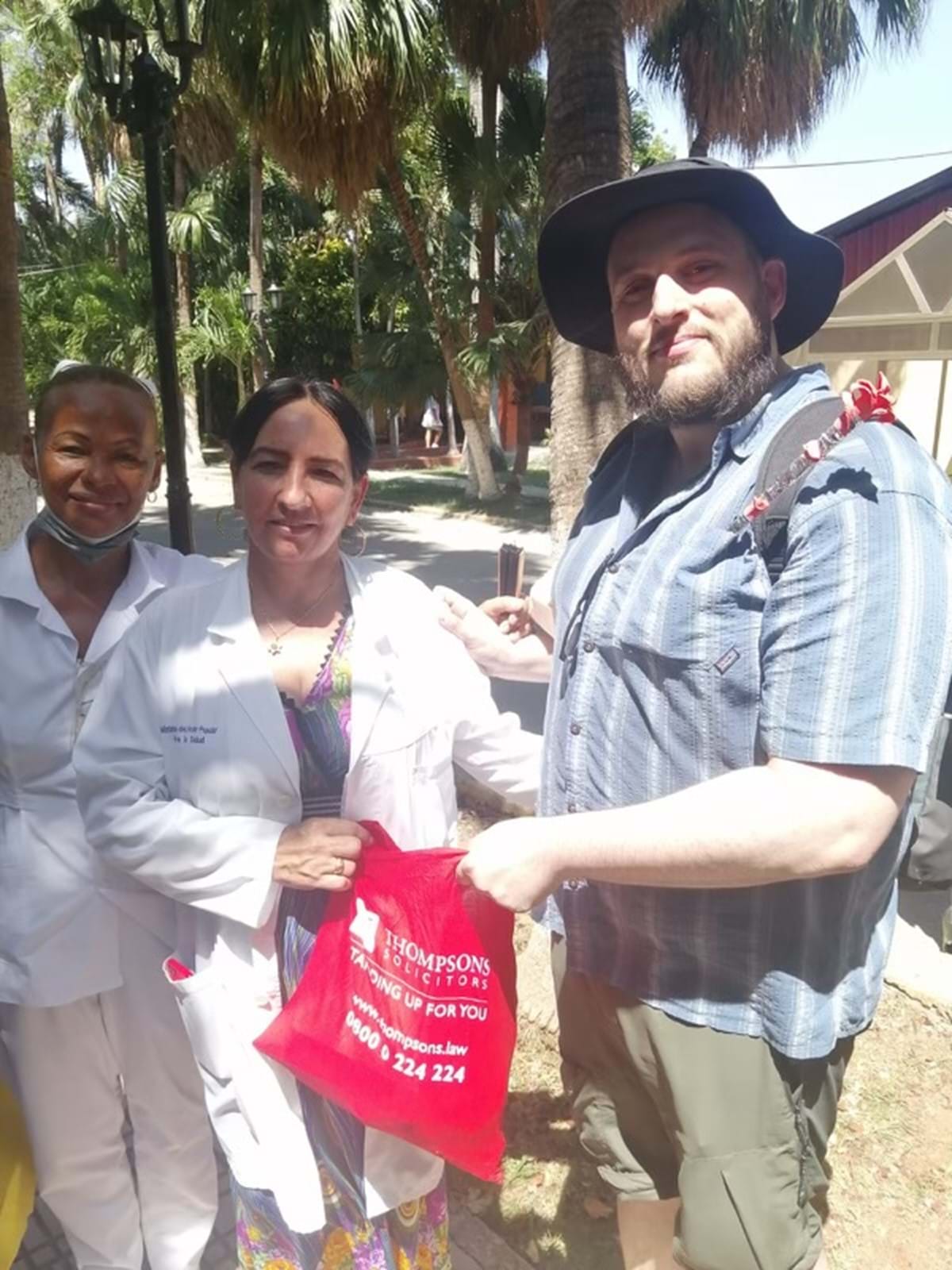 Two people holding a red bag and posing for a photo